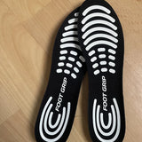 Photo client : paire de semelles Foot Grip posées sur un parquet clair